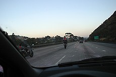 goofy motorcycle guys showing off by doing wheelies on San Diego