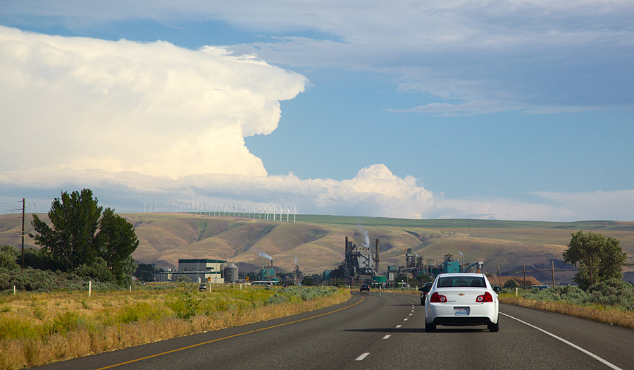 storm brewing over the hills with a wind farm and the polluting Boise paper mill