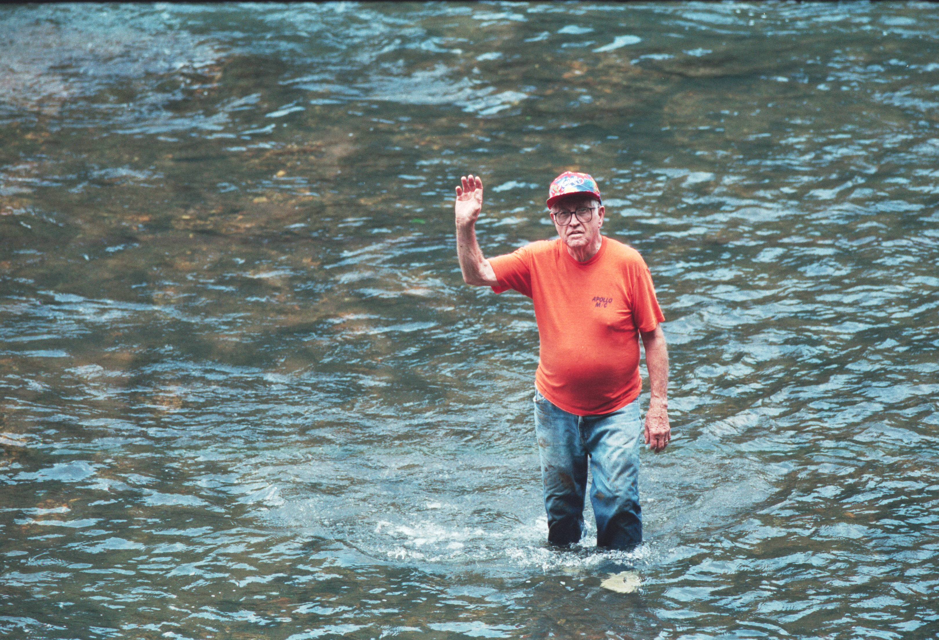 man waving from river
