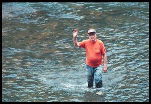 man waving from river