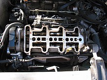 inside of a 1996 Chevrolet Lumina vin X 3.4L engine with the top bits removed while a neighbor changes the timing belt