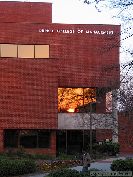 sunset reflected in the window of the Dupree College of Management