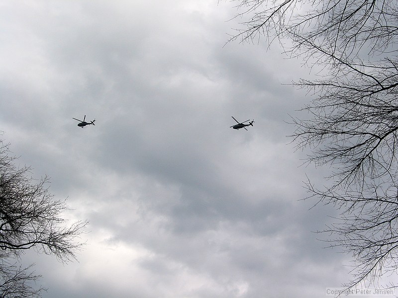 two blackhawks relatively low over campus