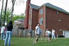 a very competitive game of croquet in the yard