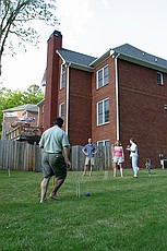a very competitive game of croquet in the yard