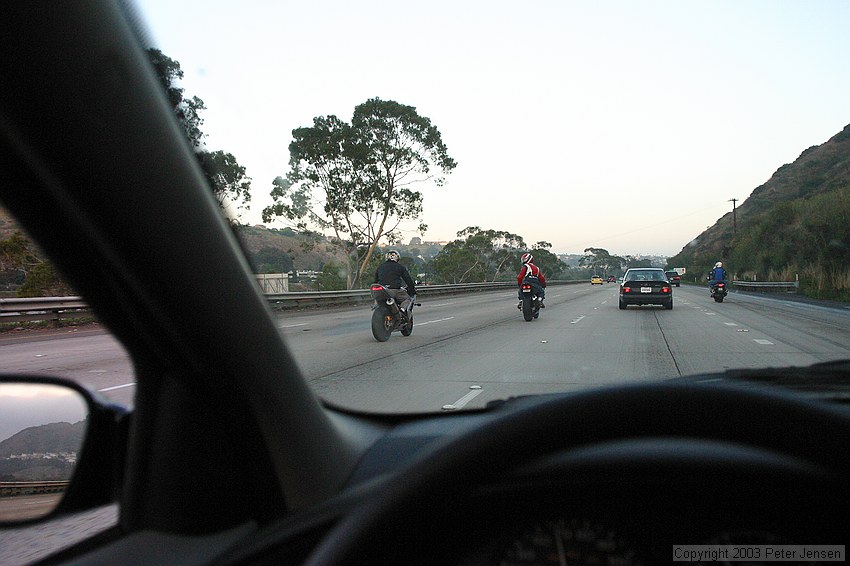 goofy motorcycle guys showing off by doing wheelies on San Diego