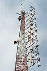 Micky Blackmon of Blackmon Site Services (recommended) preparing to move W4AQL's 2m folded loop dipole down to a side-arm mount.