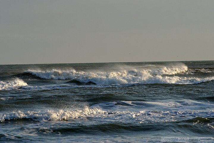 waves breaking into an onshore breeze
