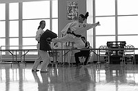 Suo Hsien kicks during her black belt test while Nick holds.  Dr. Robert Speyer and Joe Corley are administering the test.