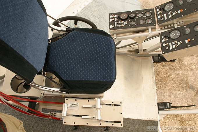 pilot's seat.  Wheel on left controls angle of side thrusters (together) and levers on the right are throttles for the thrusters.  Note oxygen bottle holders behind the seat.  Pilot said, "Well, it could hold a 64 oz big gulp, but I prefer oxygen."