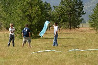 smokejumpers waiting for the practice jump hold crepe paper for wind markers; in a real fire the smoke would service this purpose