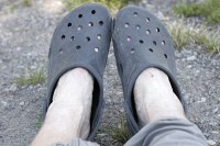 Crocs - good camp shoes.  Not so great fording streams with little pebbles, but certainly adequate.  Disadvantage over Tevas is that the soles could be punctured very easily.