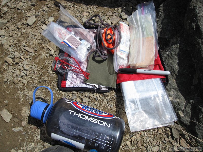 Nalgene 1L bottle and emergency kit containing a Silva compass, matches, striker, chemical water treatment tables, emergency mirror, loud whistle, LED button-cell flashlight, bandaids, moleskin, space blanket, and sharpie marker (for leaving notes/marking injuries)
