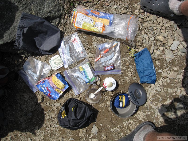 stuff sack, $40 cash and license, band-aids and allergy/pain pills, some trash, toothbrush/toothepaste, stuff sack, 1L titanium pot, Primus isobutane stove, isobutane canister, Lexan cup and spoon, stuff sack, some snack bars, spare beef stew meal, and zip-lock bags