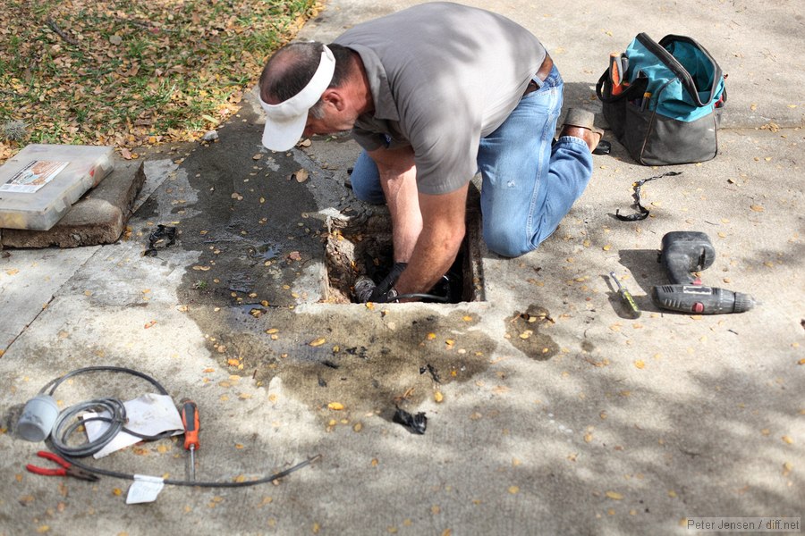 nice guy clearing black plastic from the septic pump inlet