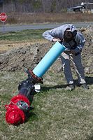 Inspecting the characteristic fire hydrant valve buried well below the earth.