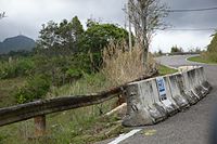 multiple levels of fail - washout fixed by jersey barriers, and washed out PVC pipe suspended by wire to guardrail