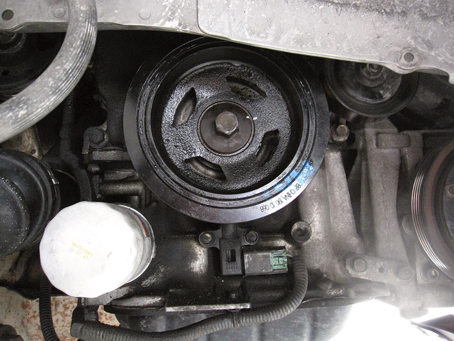 replacement crankshaft pully installed on my 2000 nissan maxima. Note the white marks on the bolt showing the ~60 degrees of rotation performed past the initial torque value per the service manual angular torqueing procedure.