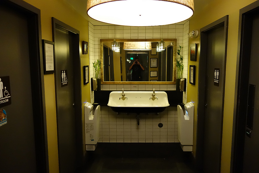 efficient and delightful restroom design - bead curtain, shared sinks, and a bunch of single-toilet rooms