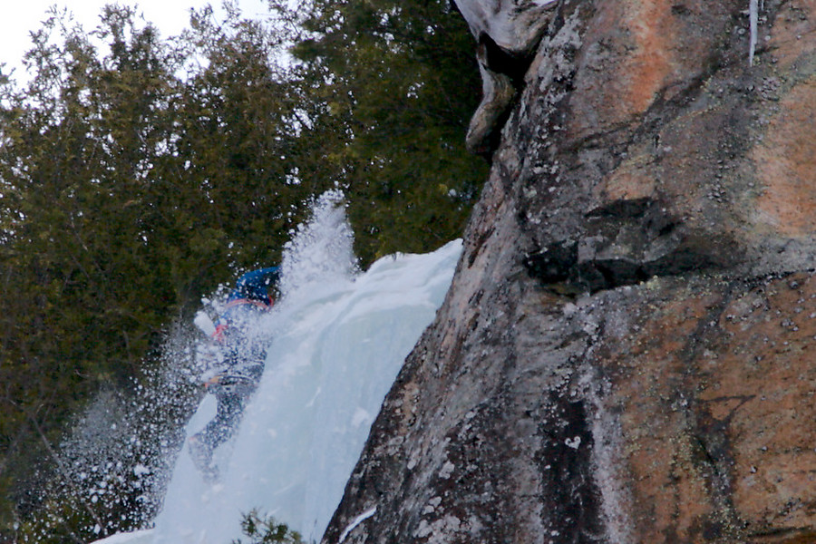 climber cleaning snow and pulling the final bulge on Rhiannon