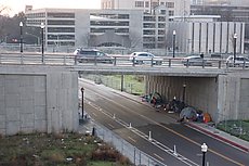 note little tiny fire they have going under the bridge and the guy sweeping the sidewalk