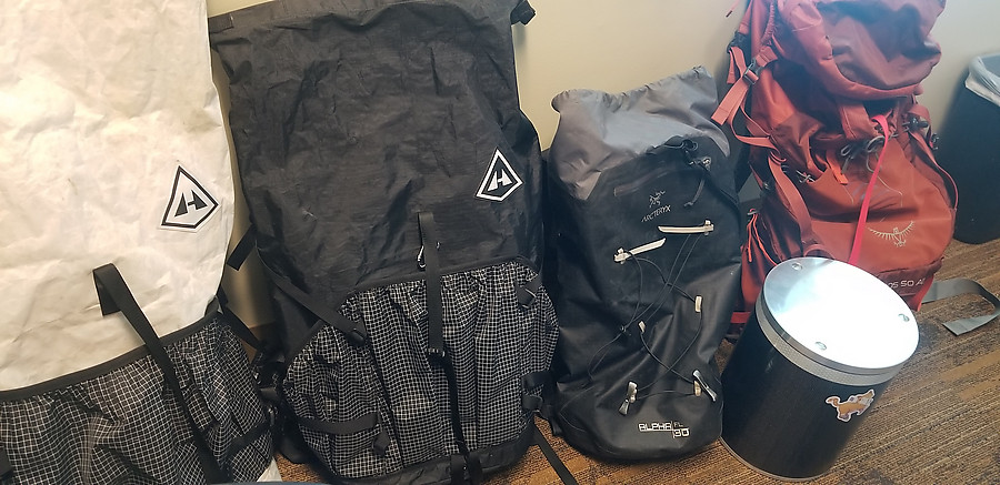 comparing some backpacks and a bear canister at work (HMG 4400 Southwest (2.45lbs), HMG 2400? Southwest, ArcTeryx Alpha FL 30 (1.4 lbs), Osprey Atmos 50 (4.5 lbs), Bearikade Blazer